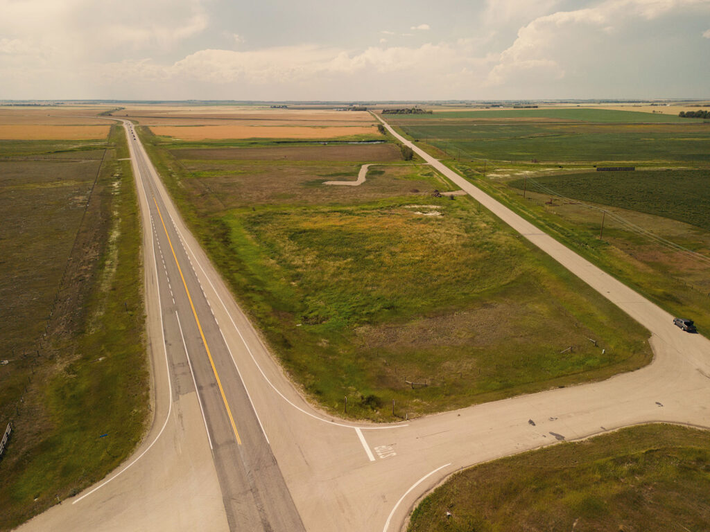 McKay Lands Parcel 2 - A highway and a dirt road are split with a big area of grass and dirt