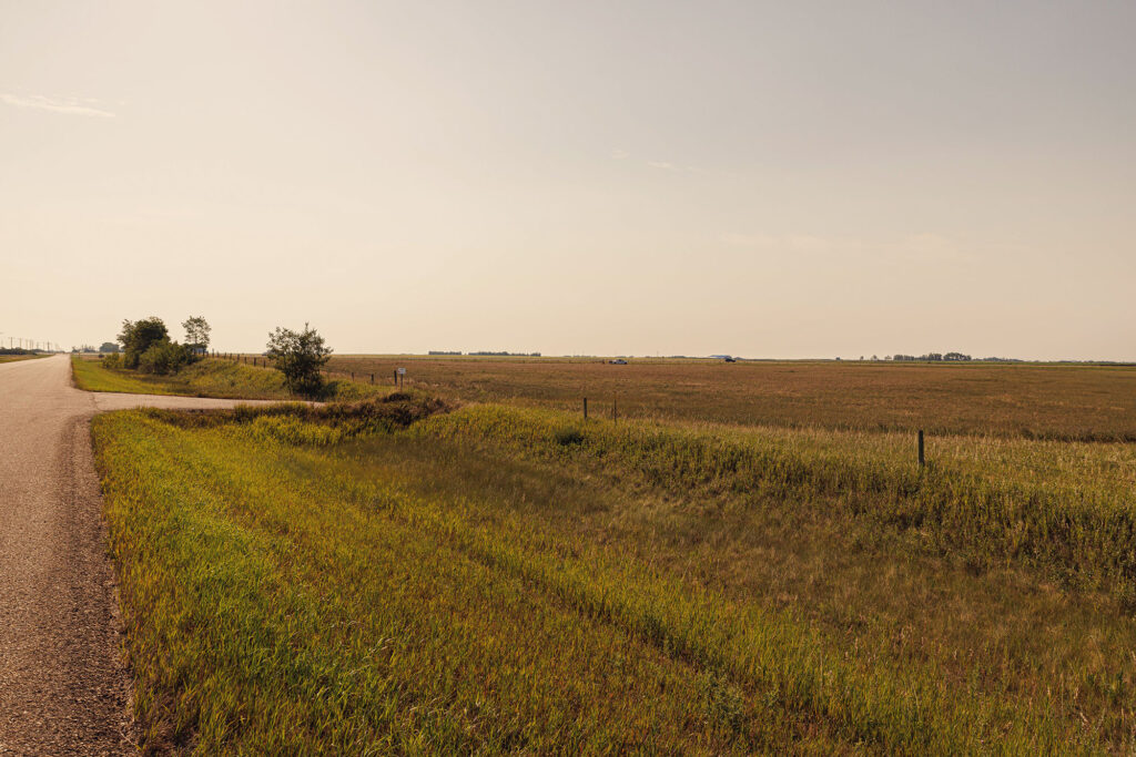 McKay Lands Parcel 4 - A stretch of highway runs next to brown and green farm land grass