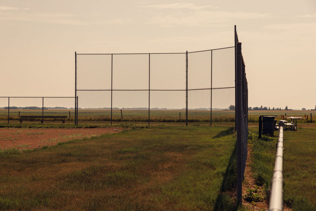 McKay Lands Community - A dark grey fence is surrounding a grassy baseball field